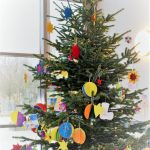 Das Bild zeigt den bunt geschmückten Weihnachtsbaum im Foyer der der Schule.